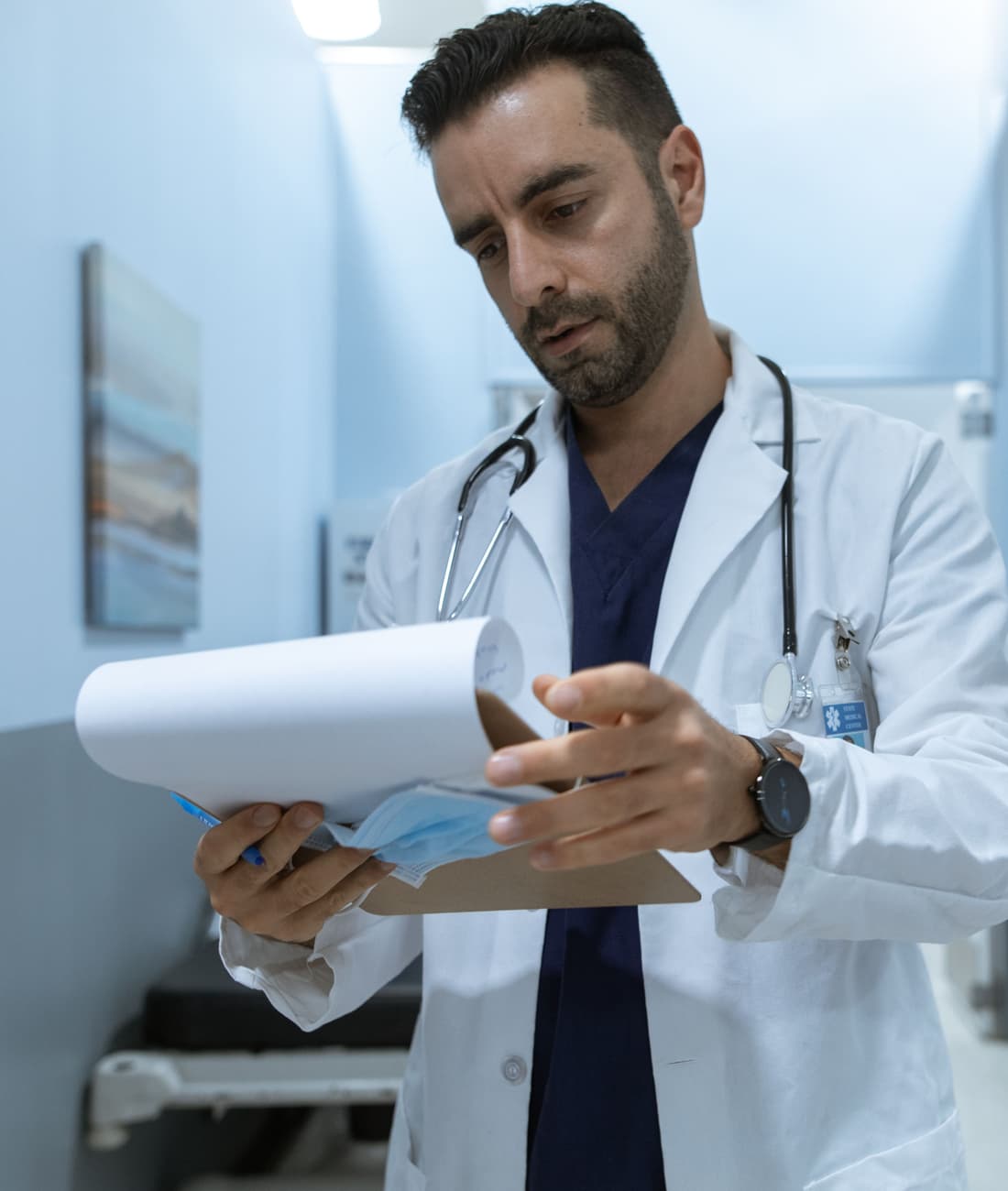 A physician reviewing patient notes in an exam room