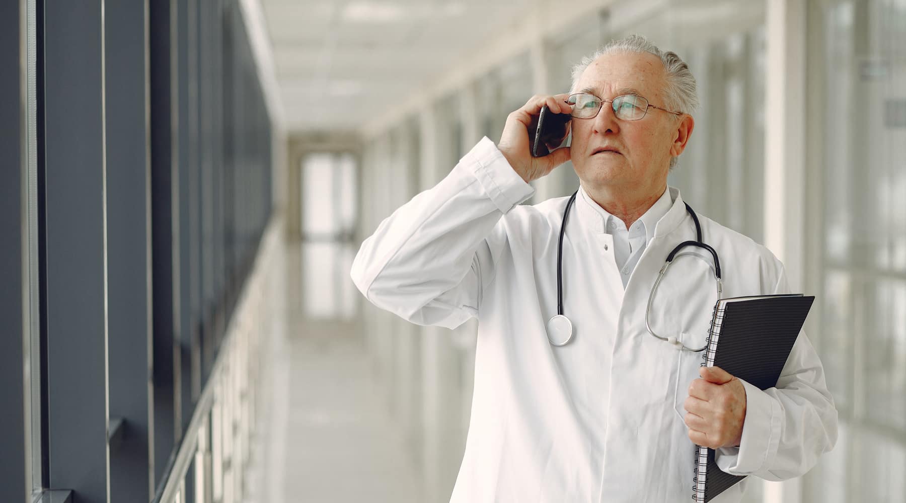 A physician taking a call in a bright clinic corridor